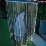 White fibre optics lights frame over an intricately painted waterfall.