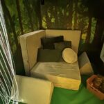 A possum play sofa configured in a seat shape with a variety of cushions on it.