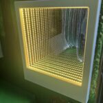 an infinity mirror reflects the colour yellow repeatedly