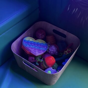 a small wood effect box contains a variety of sensory toys.