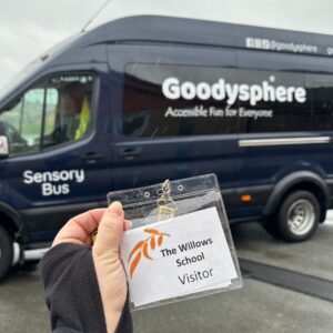 A badge that states "The Willows School" is held infront of the Goodysphere sensory bus.