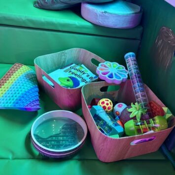 sensory toys scattered on the floor around the box