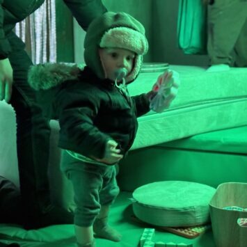a small child holds sensory toys in his hands.