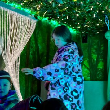 a pre-teen girl runs her hands through the fibre optic lights.
