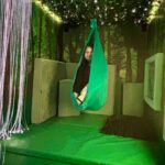 a young adult curls up into a ball in the sensory swing.