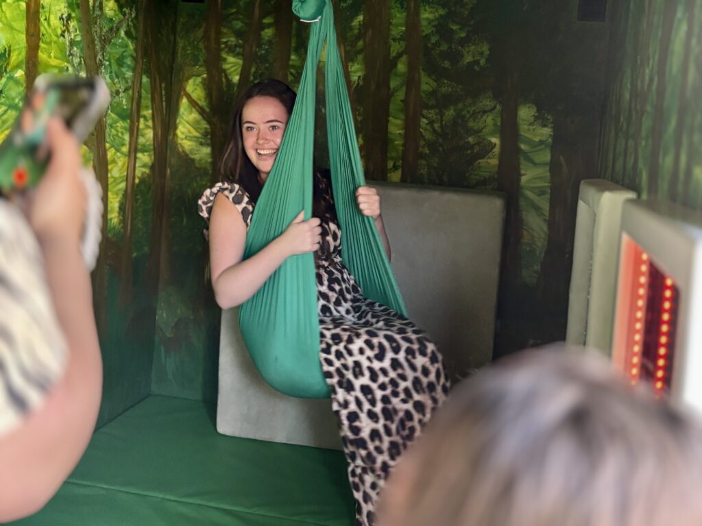 An adult female using the sensory swing inside the Goodysphere Sensory Bus