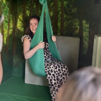 An adult female using the sensory swing inside the Goodysphere Sensory Bus