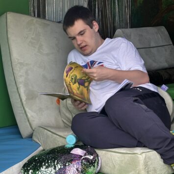 a young adult lays reading Goody: More than a hat