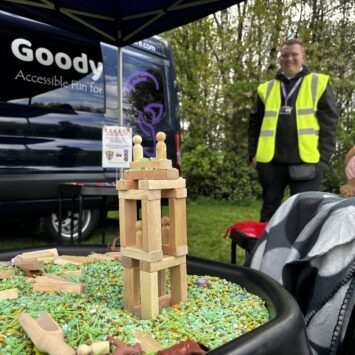 a block tower constructed on green rice in a goodysphere sensory tray