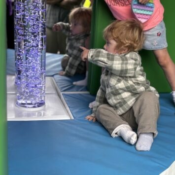 a young boy points at blue bubbles