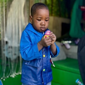 a young boy playing with a sensory toy at the bus entrance