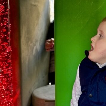 A boy looking at the red bubble tube
