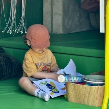 a young boy wearing an orange hat that covers his face reads Goody's Big Feelings