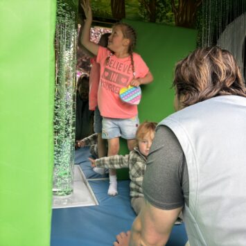 girl interacts with touch activated bubble tube