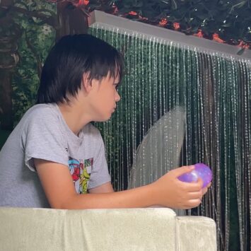 boy plays with need cube inside den