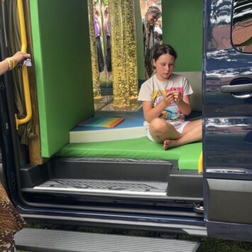 young girl watched sensory toys inside the bus