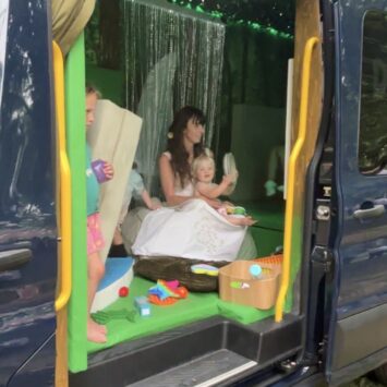 child watches outdoor cinema film from the entrance of the goodysphere sensory bus