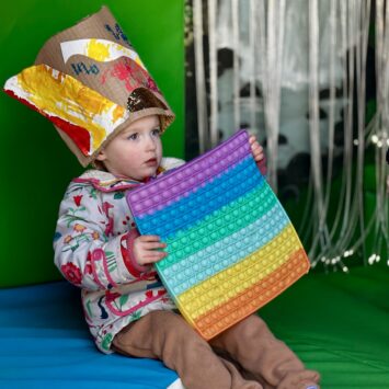 child expresses creativity wearing a crafted hat inside the bus